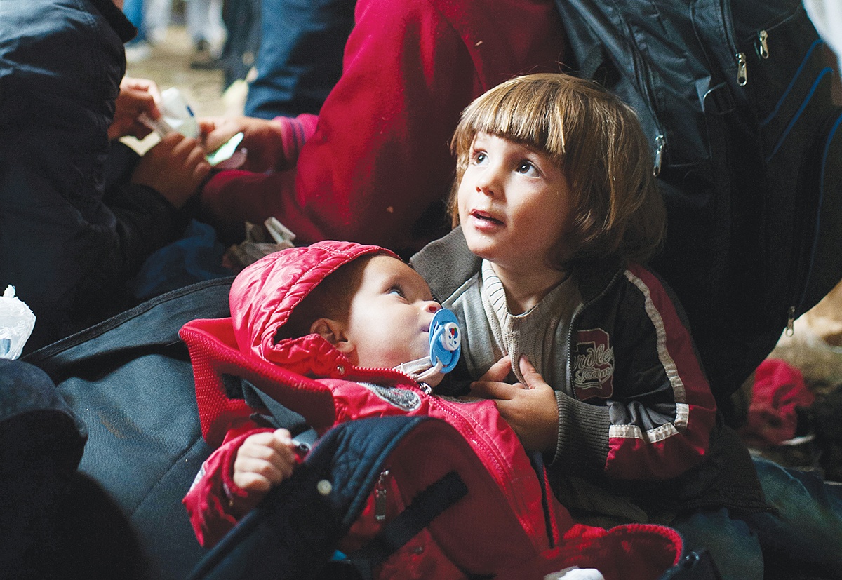 Syrian cousins wait inside a tent at Vasariste, a refugee aid point in the Serbian border town of Kanjiza. Photo by Kira Horvath for CRS